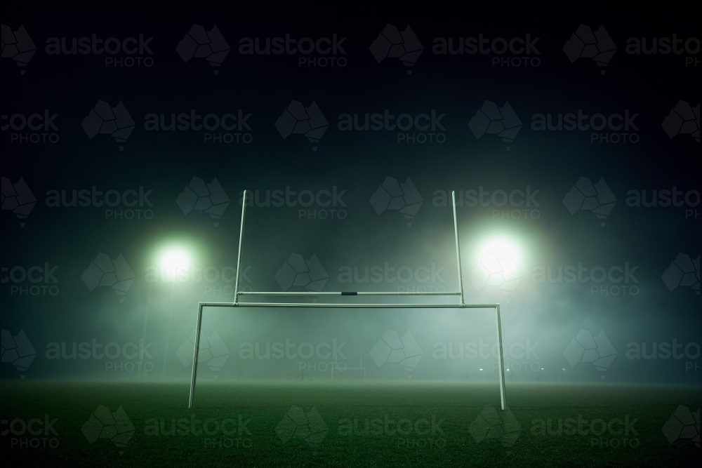 Goal posts on a sports oval in the fog at night - Australian Stock Image