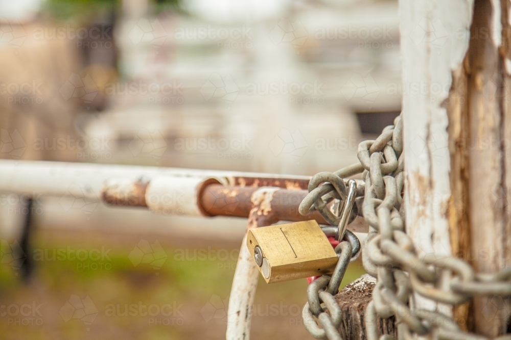 Gold lock and silver chain on a farm gate post - Australian Stock Image