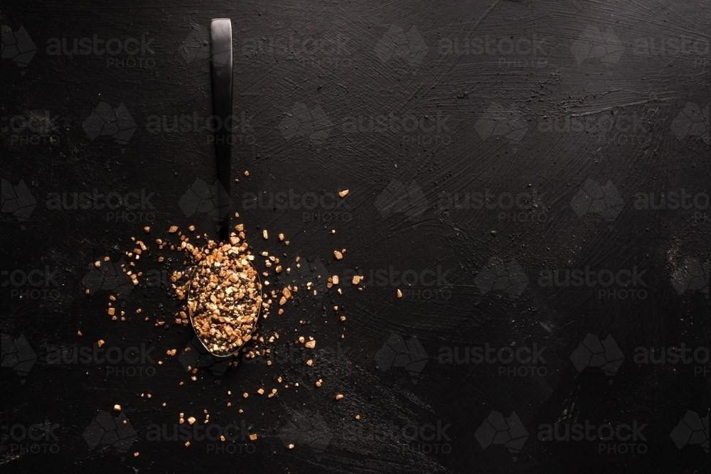 gold salt and pepper on a black background - Australian Stock Image