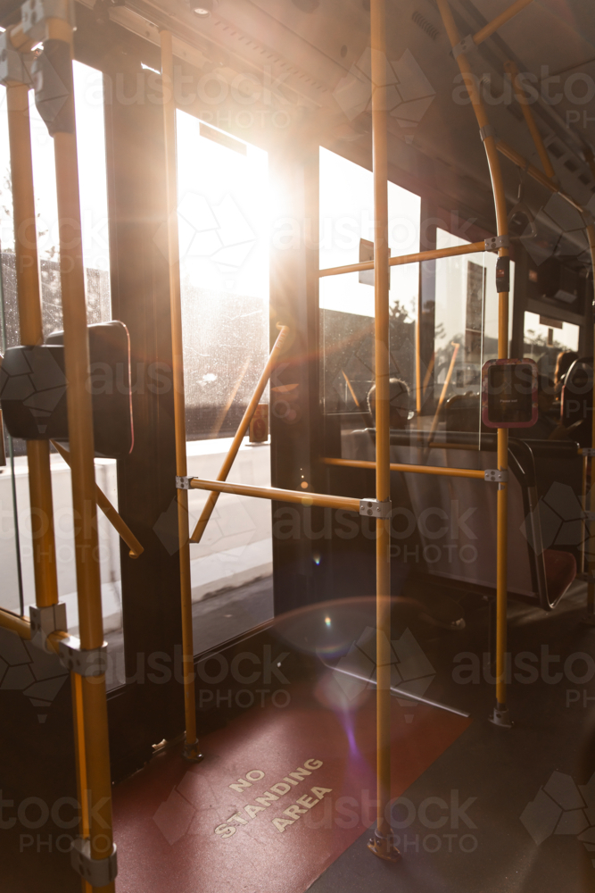 golden afternoon light streaming through the rear doors of a bus - Australian Stock Image