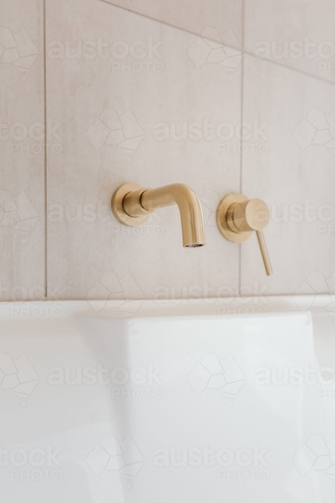 Golden bath tap and handle - Australian Stock Image