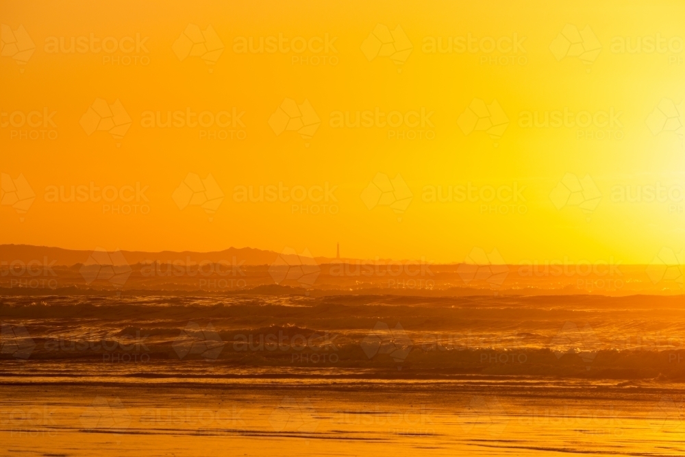 Golden Seascape with lighthouse in the distance - Australian Stock Image