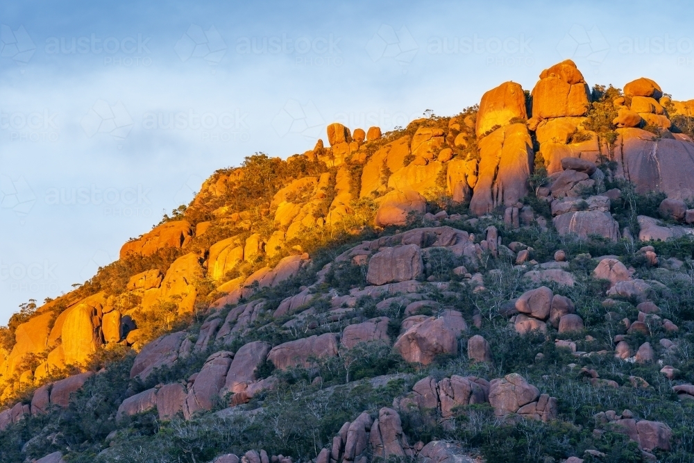 Golden sunlight hitting the tops of a rocky mountain ridge - Australian Stock Image