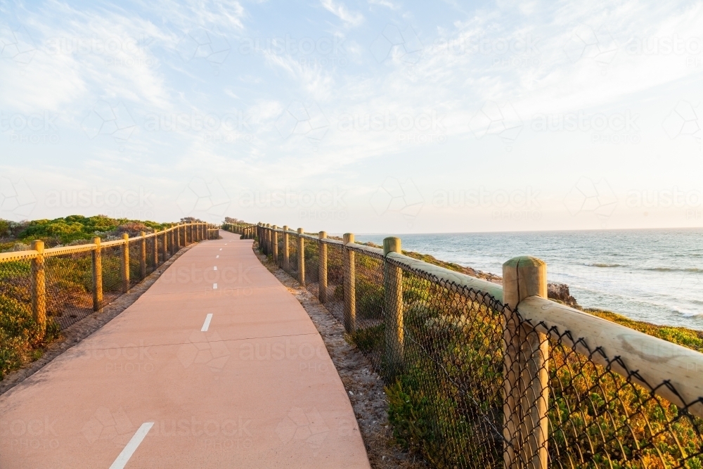 Golden sunlight shining over coastal walking path - Australian Stock Image