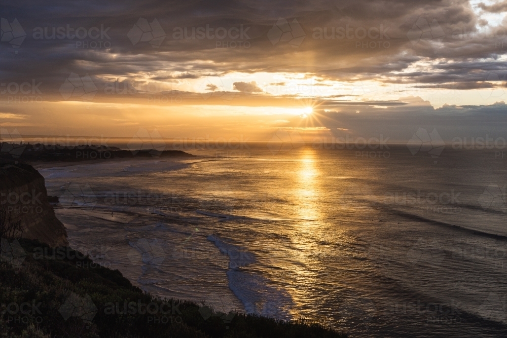 Golden sunrise on the horizon at the beach - Australian Stock Image