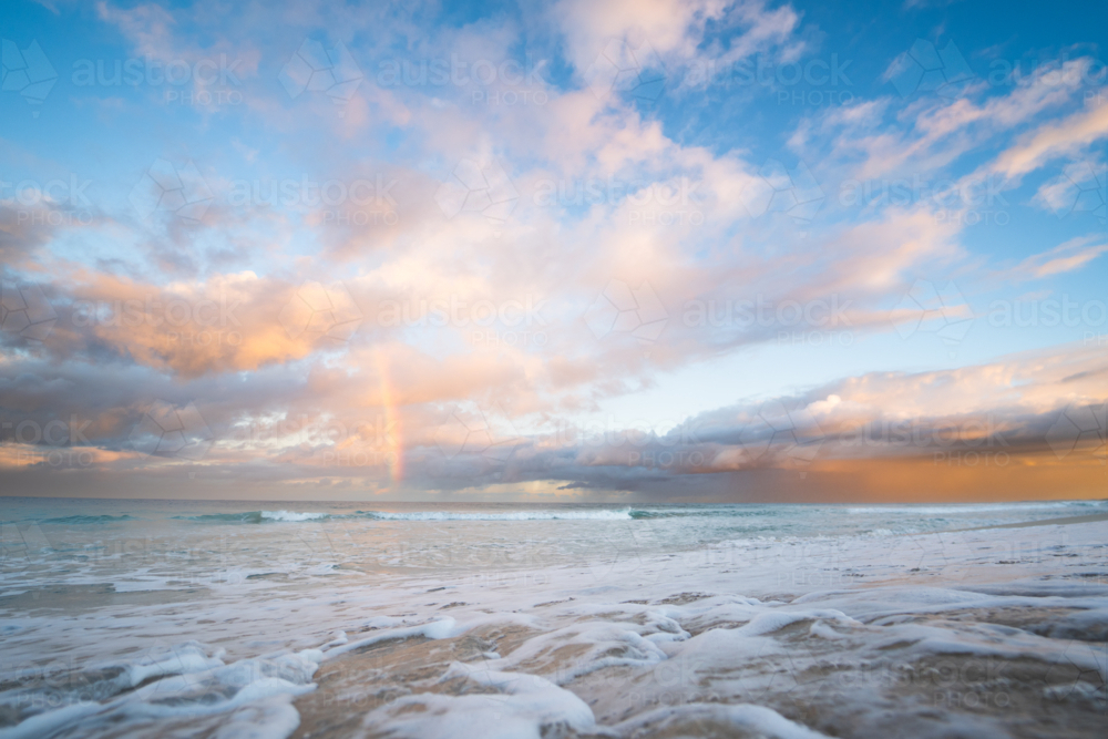 Golden sunset light reflecting on wet beach sand and ocean waves at Scarborough Beach, Perth - Australian Stock Image