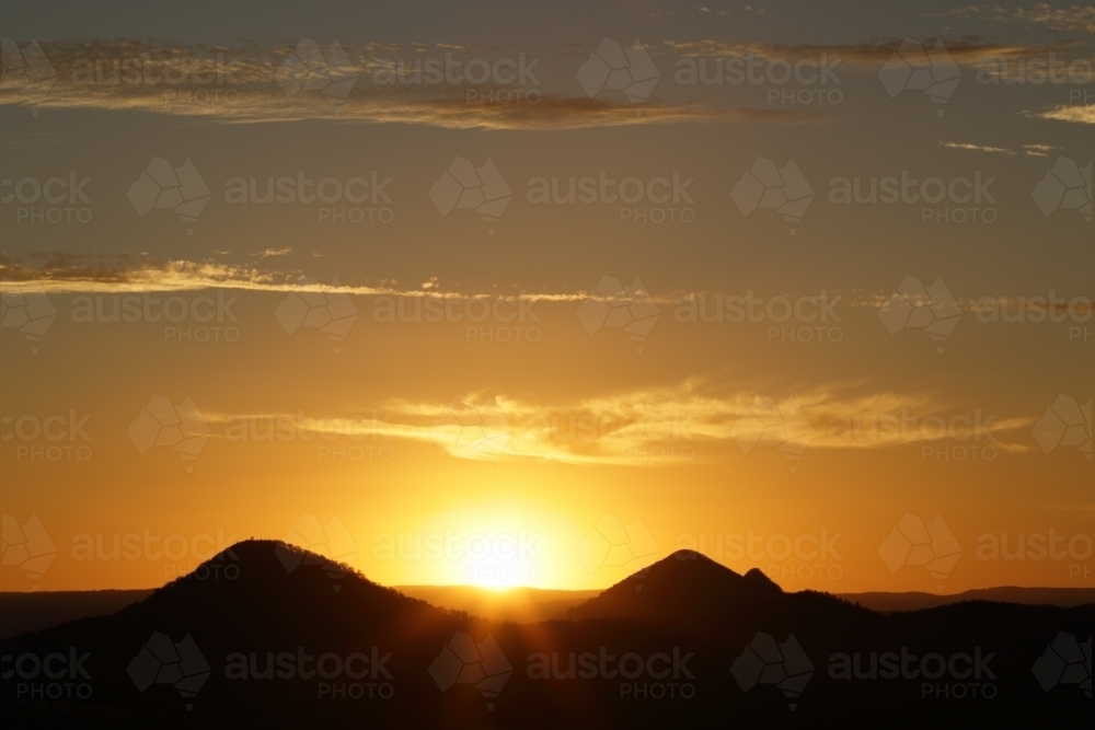 Golden sunset over the Glasshouse Mountains from Wild Horse Mountain Lookout - Australian Stock Image