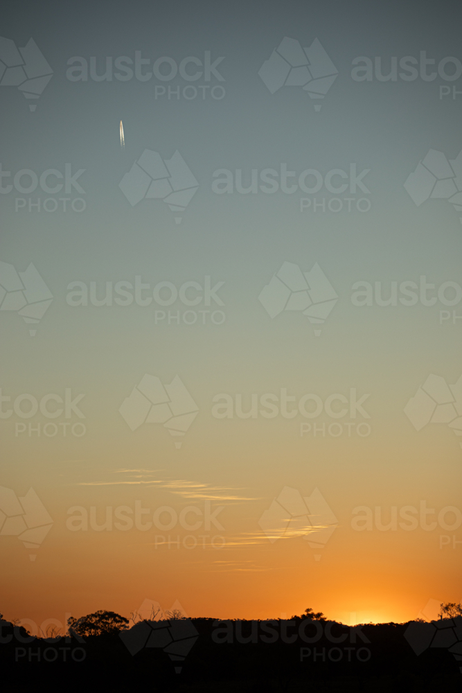 Golden sunset with short jet trail in a big sky - Australian Stock Image