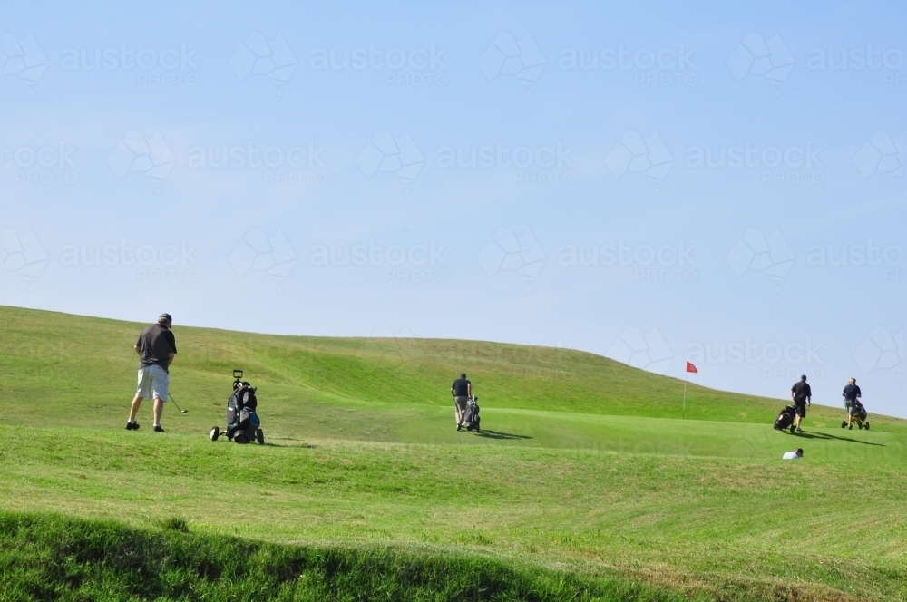 Golfers on green with blue sky - Australian Stock Image