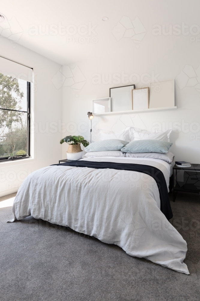 Gorgeous bedroom with luxury linen and a pot plant - Australian Stock Image