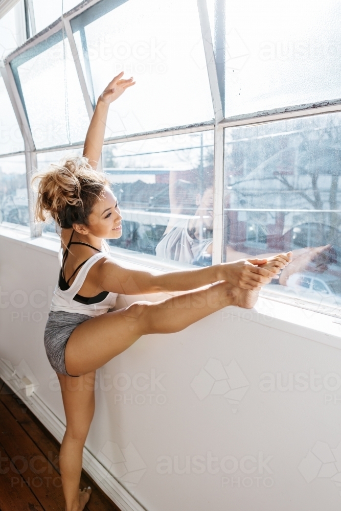 Gorgeous female dancer striking a pose in during dance practice - Australian Stock Image