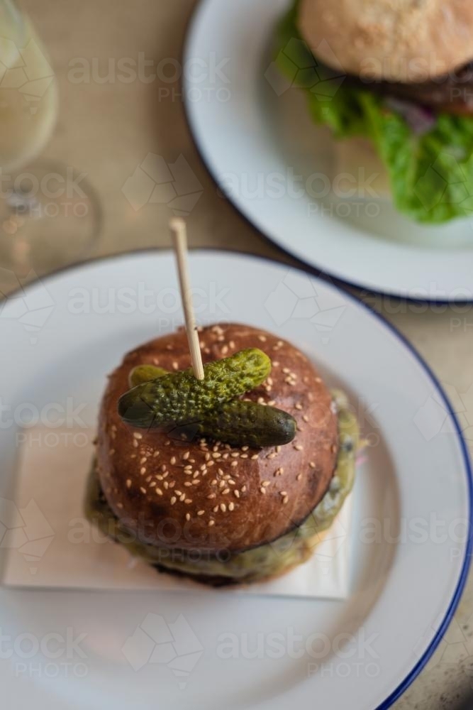 gourmet hamburger with pickles on top - Australian Stock Image