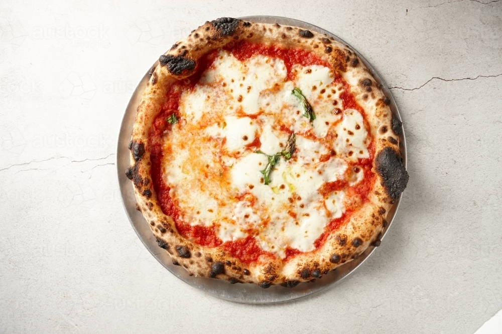 Gourmet wood fired pizza on table - Australian Stock Image