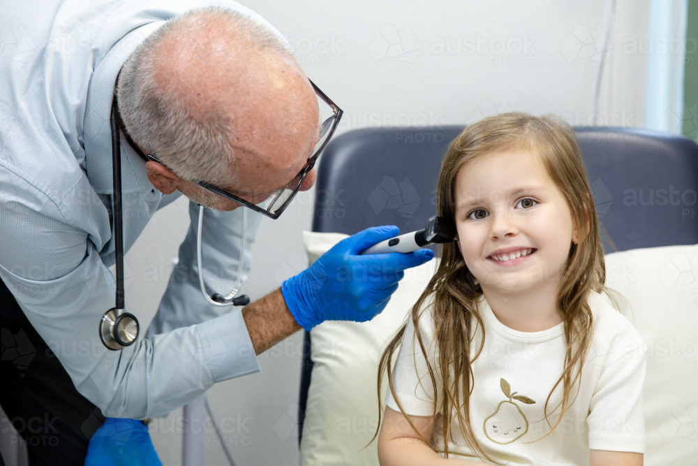 GP doctor doing health check-up for pre-schooler girl at clinic - Australian Stock Image