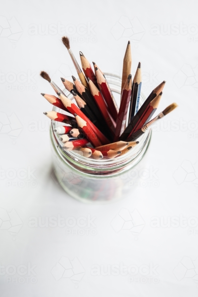Graded graphite art pencils in jar on white - Australian Stock Image