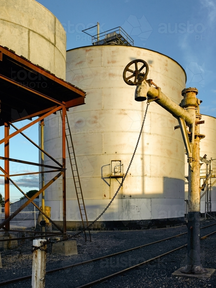 Grain silos and water pipe on a railway track in the country - Australian Stock Image