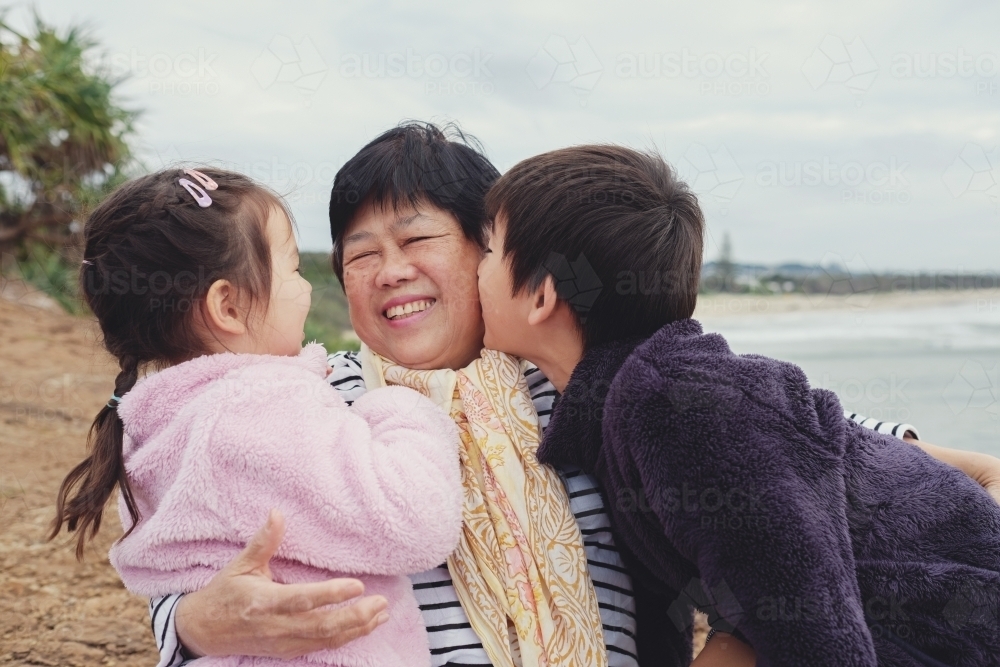 Grandchildren kissing their grandmother - Australian Stock Image