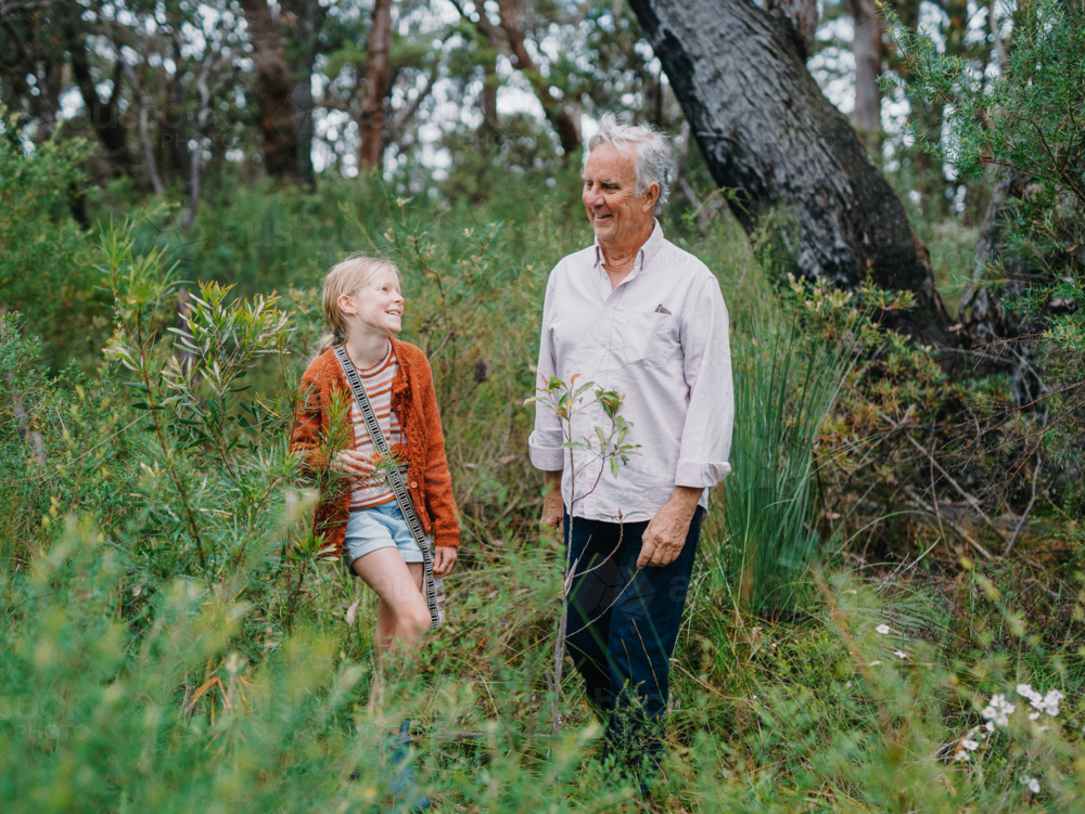 Grandfather exploring Australian Bushland with granddaughter smiling together - Australian Stock Image
