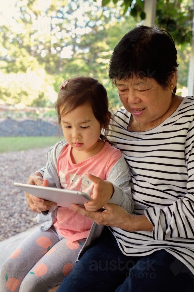Grandmother and granddaughter using tablet - Australian Stock Image