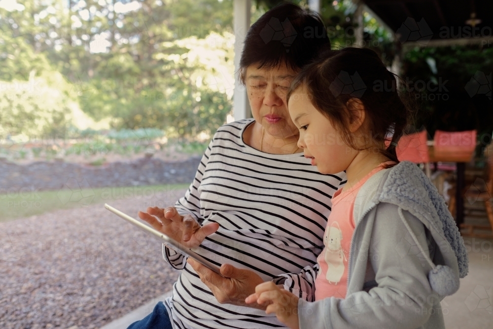 Grandmother and granddaughter using tablet - Australian Stock Image
