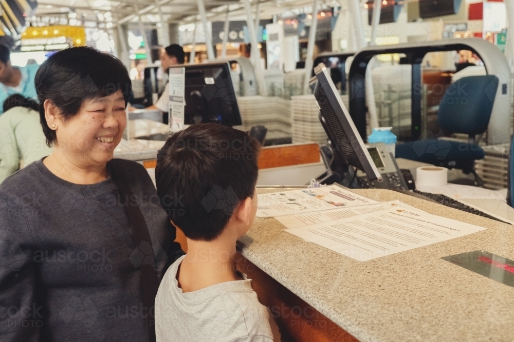 Grandmother and grandson at airport check-in - Australian Stock Image