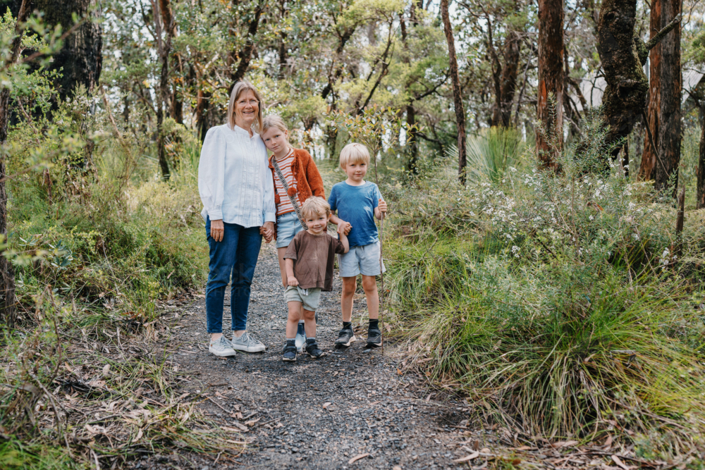 Grandmother enjoying Australian Bushland with her Grandchildren standing on path together - Australian Stock Image