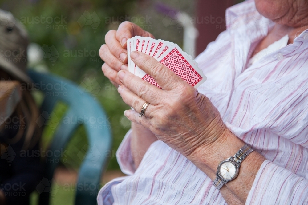 Grandmother holding a hand of cards - Australian Stock Image