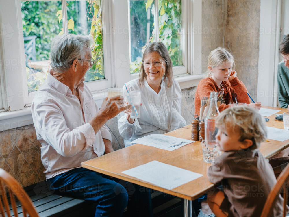 Grandparents enjoying lunch with their young grandchildren - Australian Stock Image