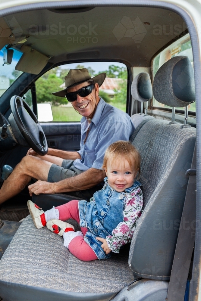 Image of Granduncle farmer with baby grand niece sitting in farm ute ...
