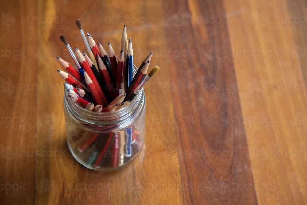 Graphite art pencils in jar on wood with copy space - Australian Stock Image