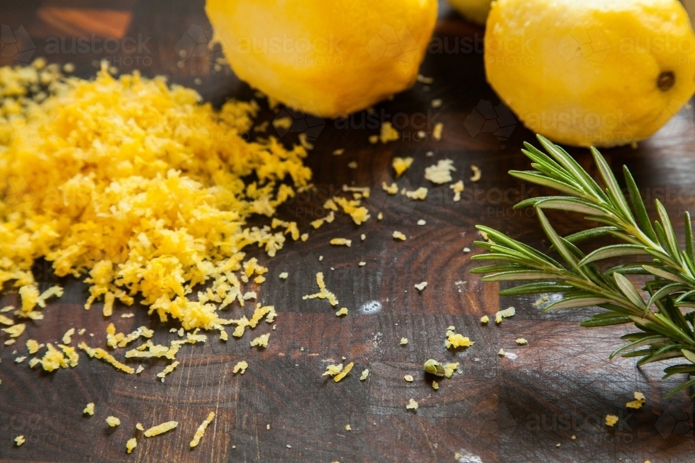 Grated lemon skin and lemons with rosemary - Australian Stock Image