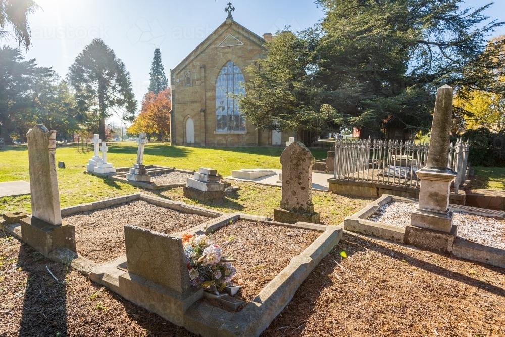Graves in a cemetery at the back of church - Australian Stock Image