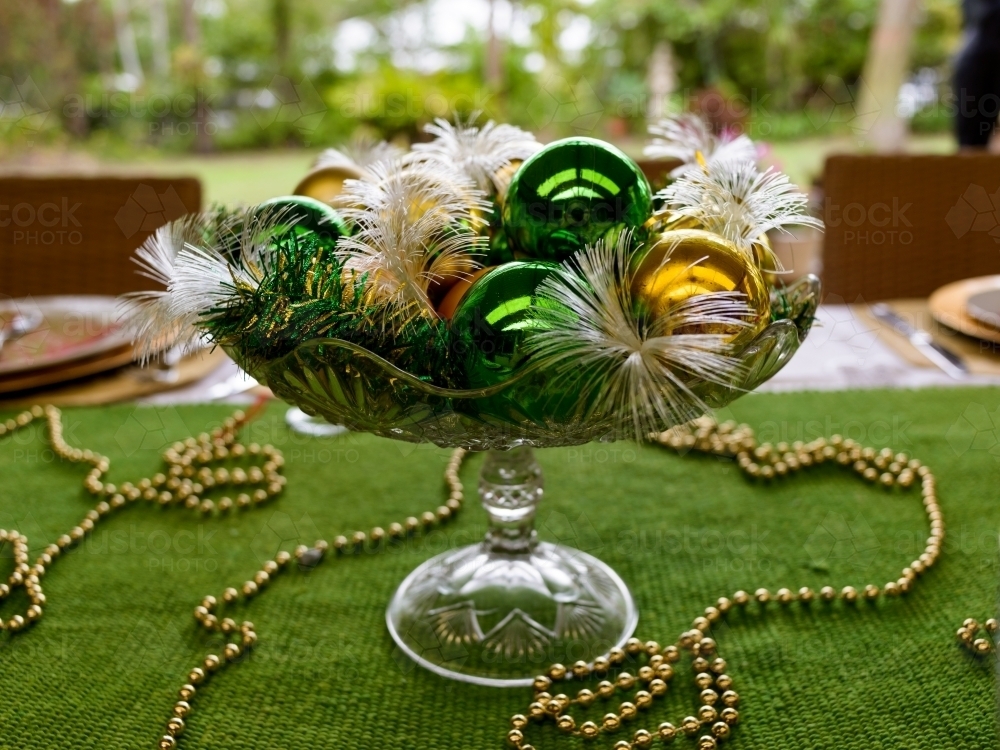 Image of green and gold christmas table decorations in blurred outdoor Image of Green and Gold Christmas table decorations in blurred outdoor