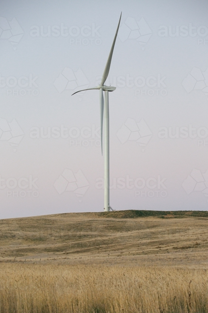 Green energy wind turbine in the countryside at dusk - Australian Stock Image