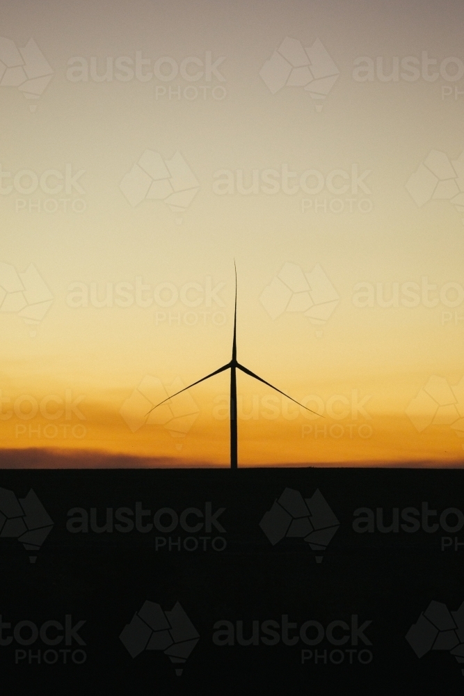 Green energy wind turbine silhouette in the countryside at dusk - Australian Stock Image