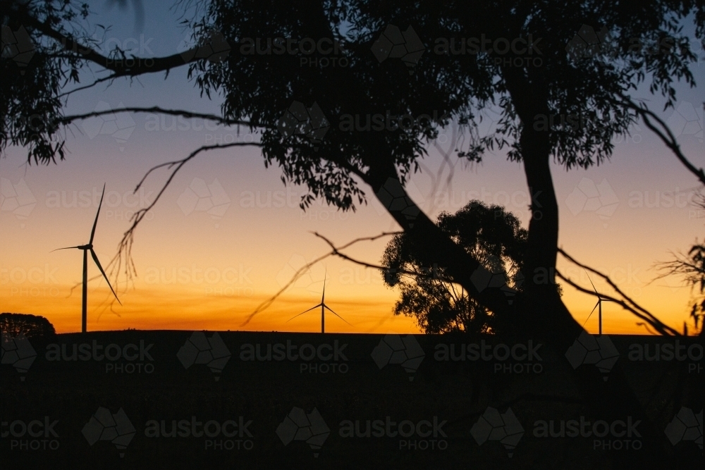 Green energy wind turbine silhouette in the countryside at dusk - Australian Stock Image