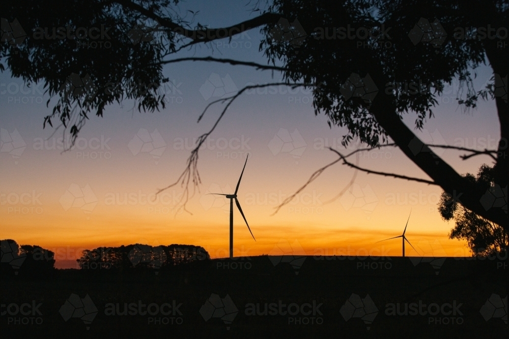 Green energy wind turbine silhouette in the countryside at dusk - Australian Stock Image
