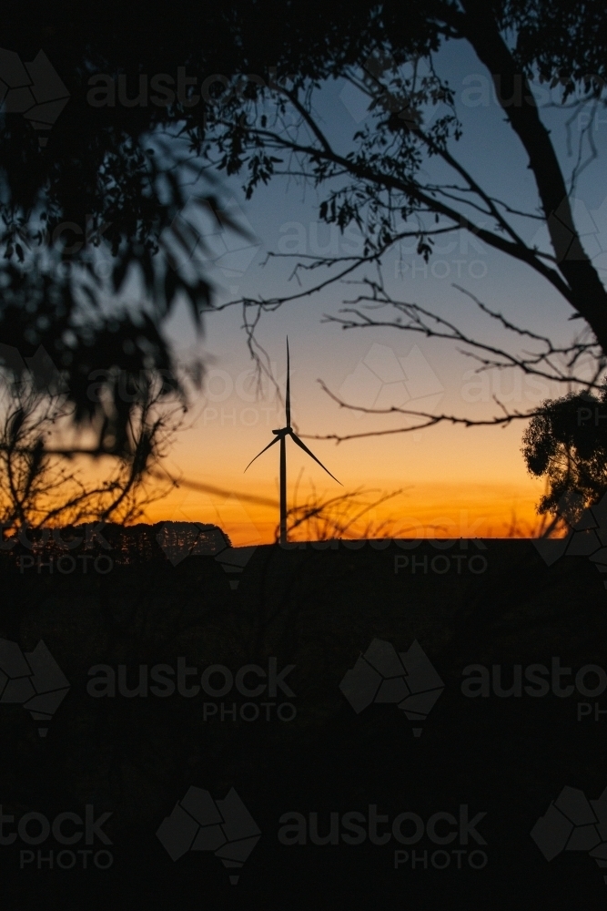 Green energy wind turbine silhouette in the countryside at dusk - Australian Stock Image