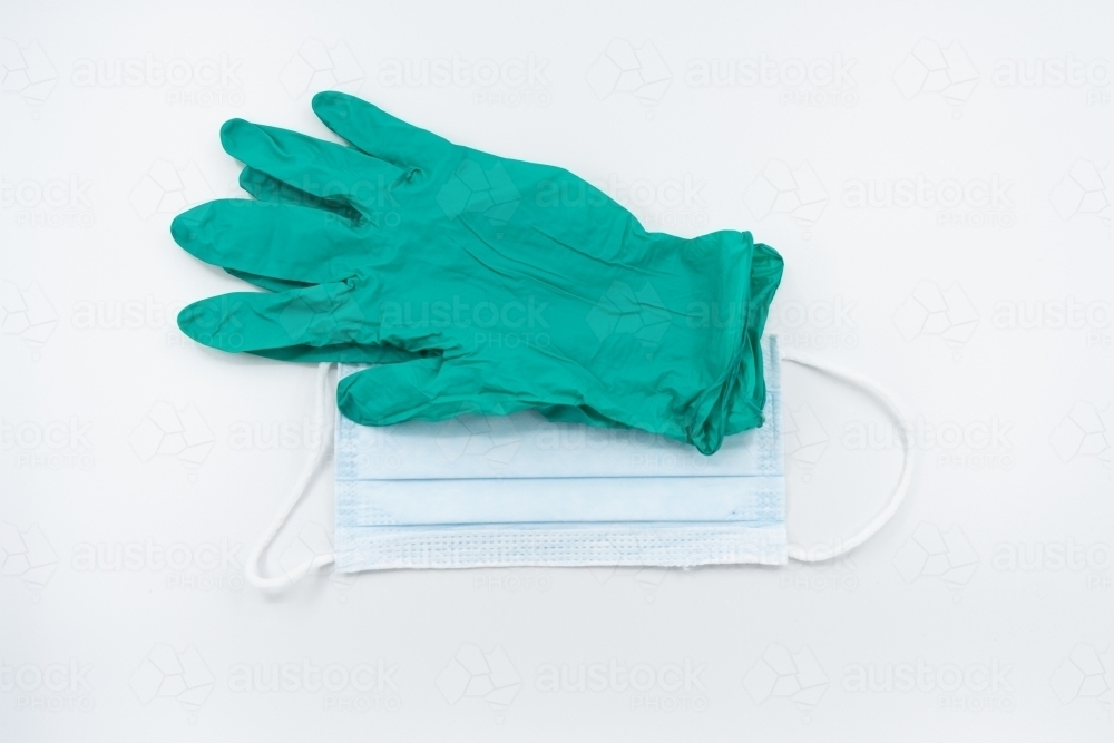 Green gloves and surgical mask flatlay - Australian Stock Image