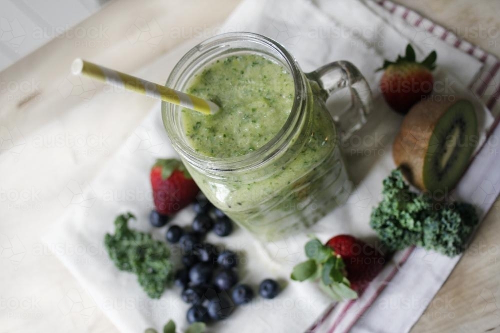 Image of Green kiwi fruit and kale smoothie with berries Austockphoto