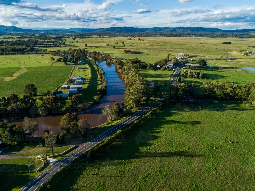 Green landscape with river and road winding through green countryside - Australian Stock Image