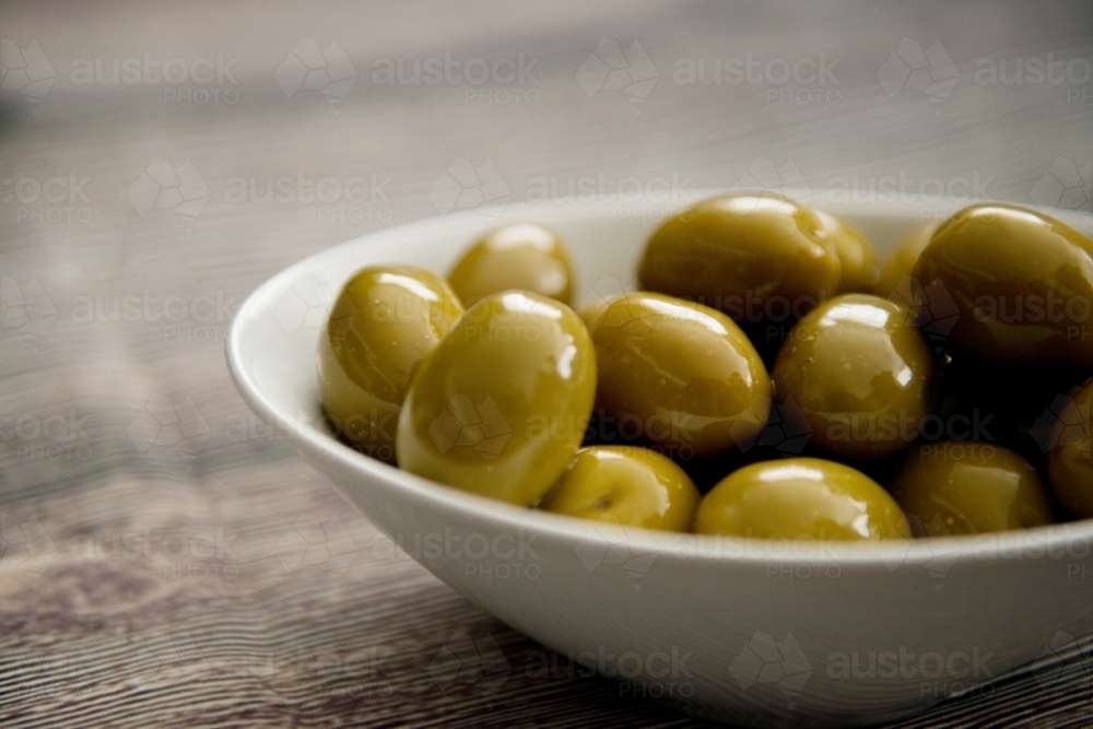 Green Olives In A Bowl on Wood - Australian Stock Image