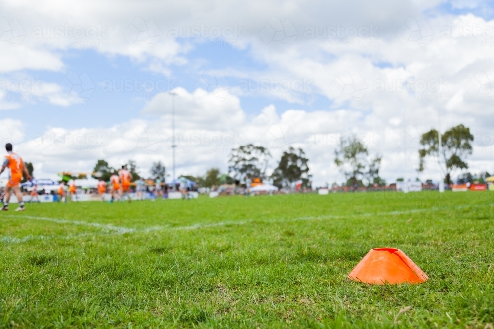 Green playing field with out of focus sport players in the background - Australian Stock Image