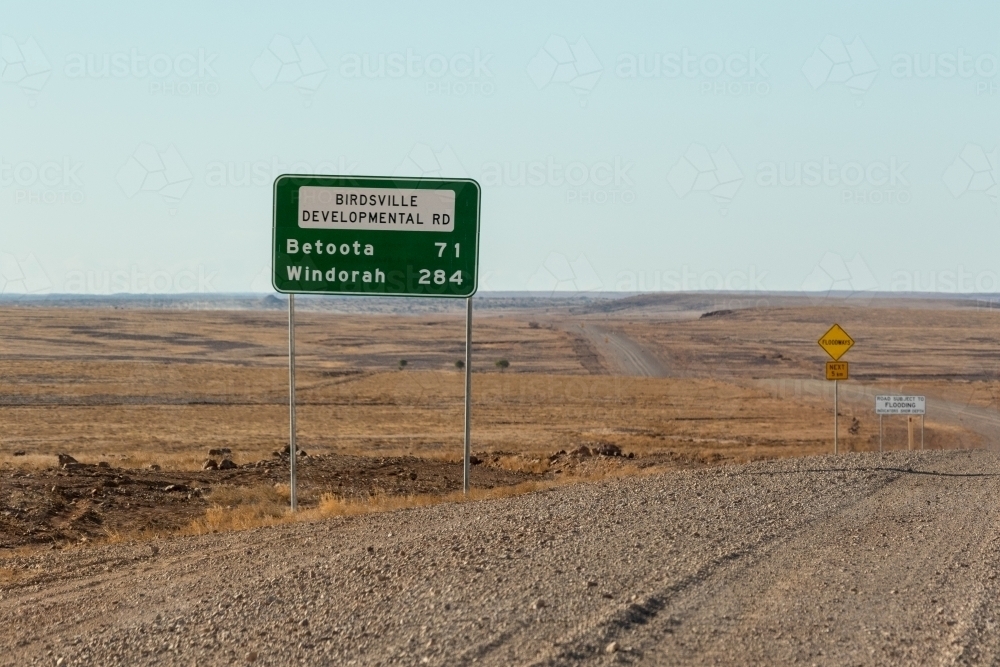Green road sign on gravel road with nothing in the distance - Australian Stock Image