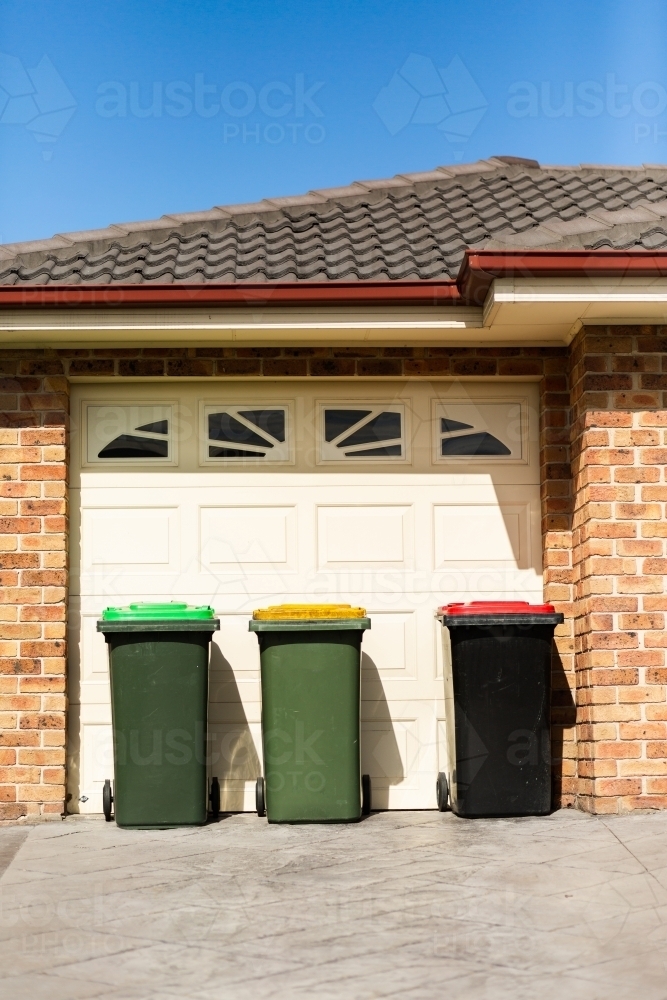 Green waste bin, recycling council bin and general waste bin outside of home - Australian Stock Image