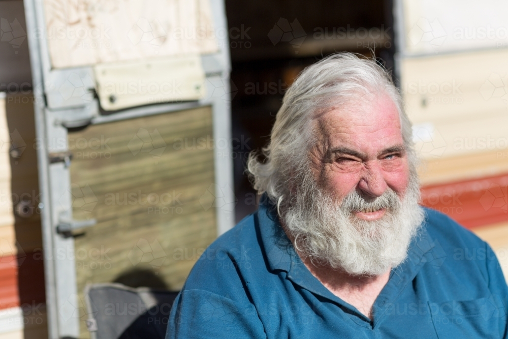 Grey haired old man squinting with the heat of the sun - Australian Stock Image