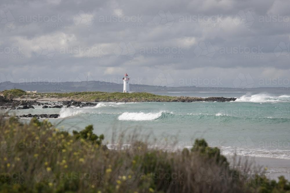 Griffiths Island coast with distant white Lighthouse at Port Fairy - Australian Stock Image