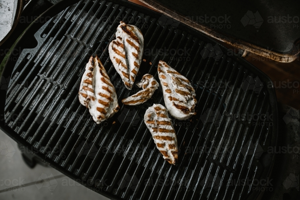 grilled chicken breast on a BBQ barbeque hot plate with the lid open - Australian Stock Image