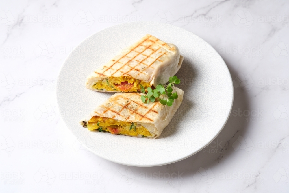 Grilled wrap cut in half topped with a herb - Australian Stock Image