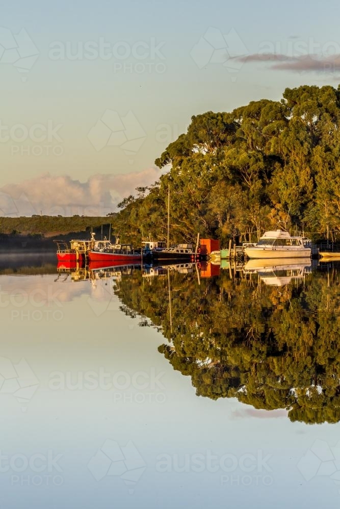 Group of Boats Moored on Glassy Water with Reflections - Australian Stock Image